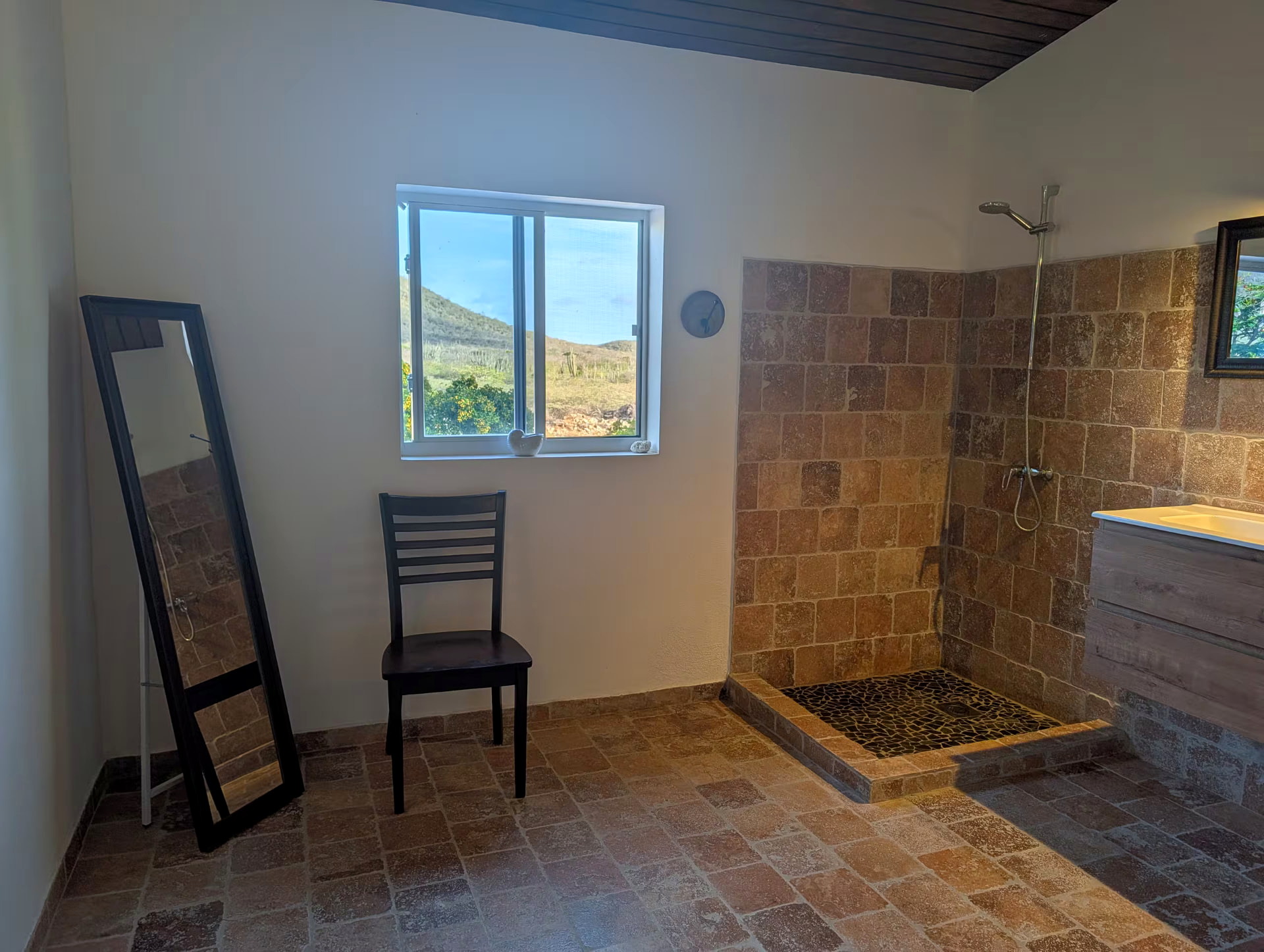 Spacious bathroom with a natural-stone walk-in shower