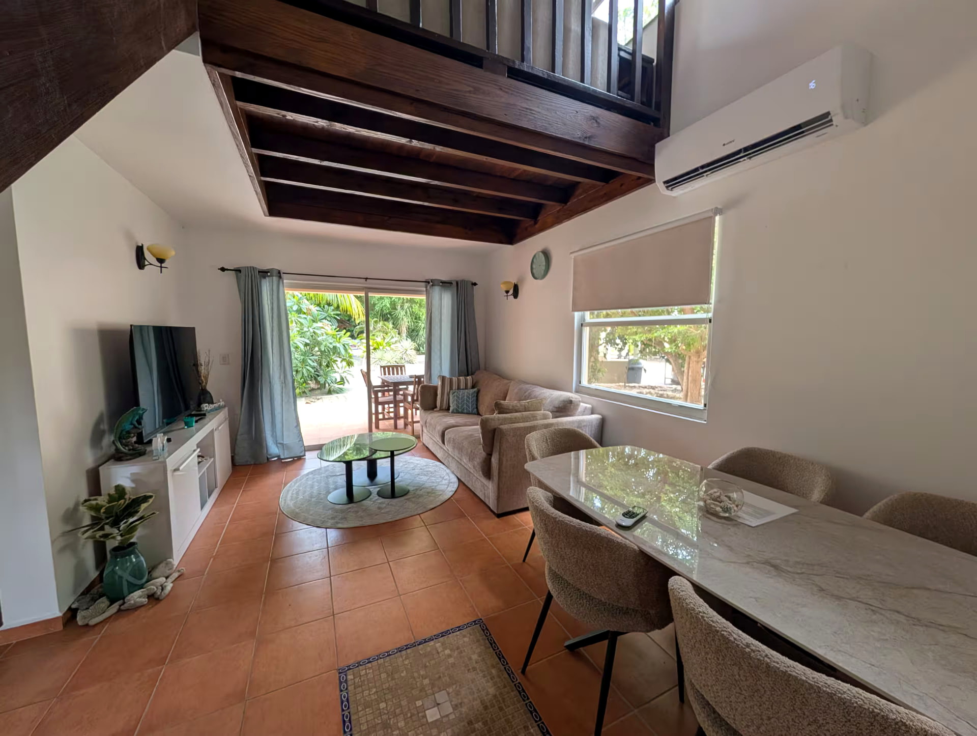 Bright ground-floor living room with television and dining area